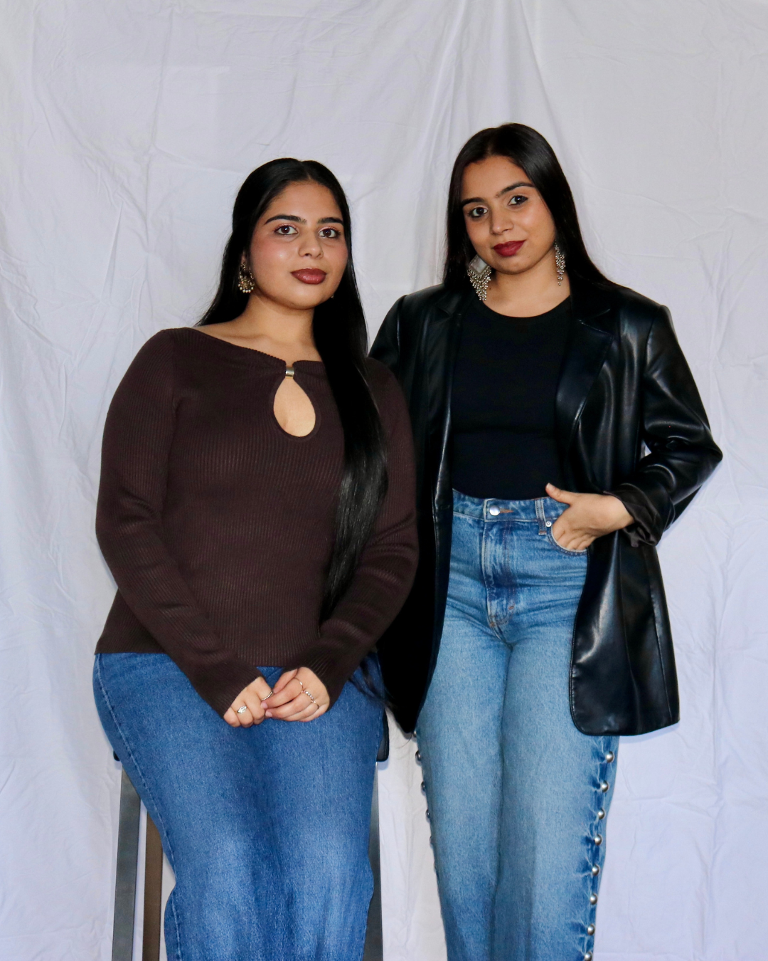 Two women standing side by side against a plain background